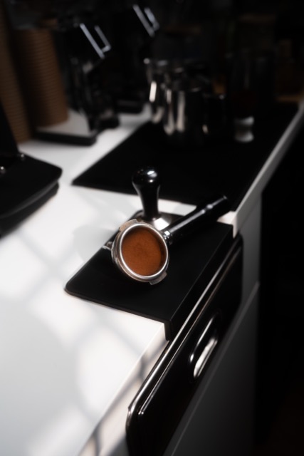 Siebträger mit frisch gemahlenem Kaffee auf der Bar